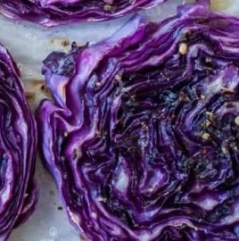 Plate of roasted cabbage steaks seasoned with spices and herbs