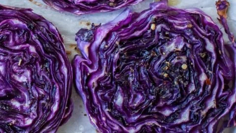 Plate of roasted cabbage steaks seasoned and garnished