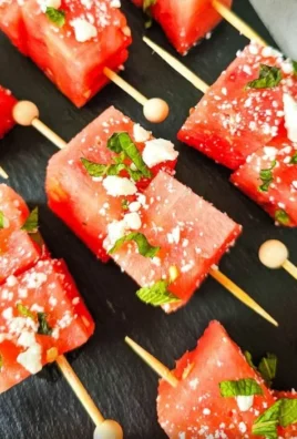 Colorful watermelon feta skewers with fresh herbs and a drizzle of balsamic glaze.