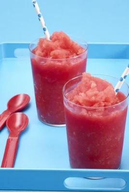 Refreshing watermelon slushy in a glass with ice and a slice of watermelon
