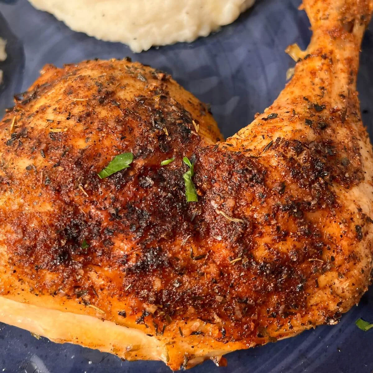 Delicious oven baked chicken quarters garnished and ready to serve.