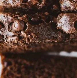 Freshly baked chocolate zucchini bread loaf on a wooden cutting board.