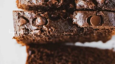 Freshly baked chocolate zucchini bread loaf on a wooden cutting board.