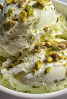 Creamy pistachio cottage cheese ice cream in a bowl with pistachios on top.