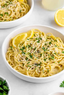 Creamy vegan lemon pasta garnished with fresh herbs and lemon zest
