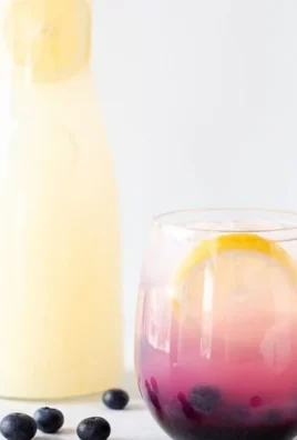 Glass of refreshing easy blueberry lemonade with fresh blueberries and lemon slices