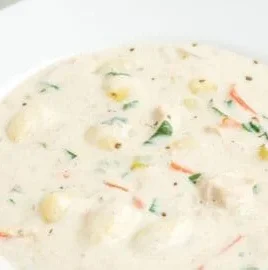 Bowl of homemade Olive Garden chicken gnocchi soup with fresh herbs and butter