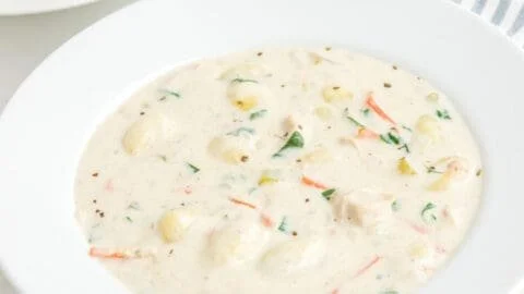 Bowl of homemade Olive Garden chicken gnocchi soup with fresh herbs and butter
