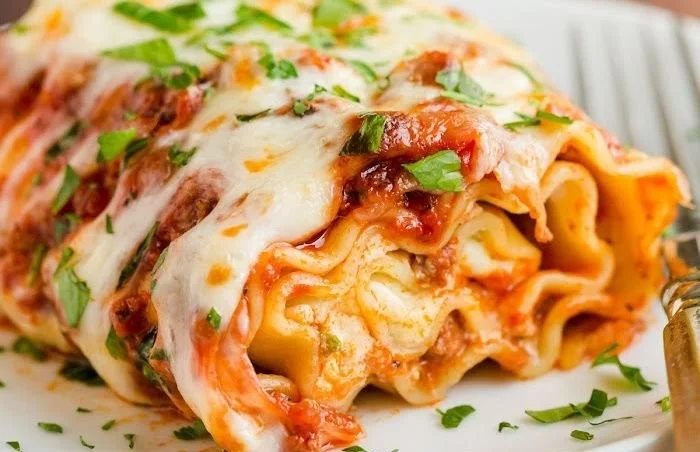 Delicious lasagna roll-ups filled with cheese and sauce served on a plate