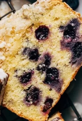 Freshly baked lemon blueberry loaf with a golden crust and vibrant blueberries