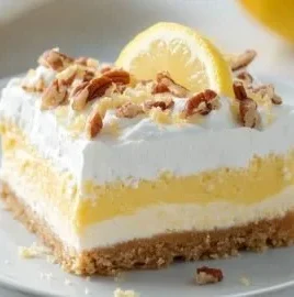 Delicious Lemon Lush dessert served in a glass dish with fresh lemon slices
