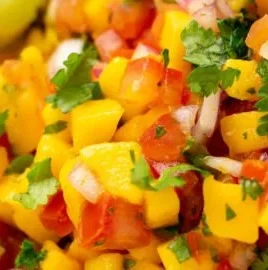 Fresh Mango Salsa Fresca served in a bowl with chips and garnishes