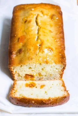 Sliced orange marmalade bread on a wooden board with a jar of marmalade