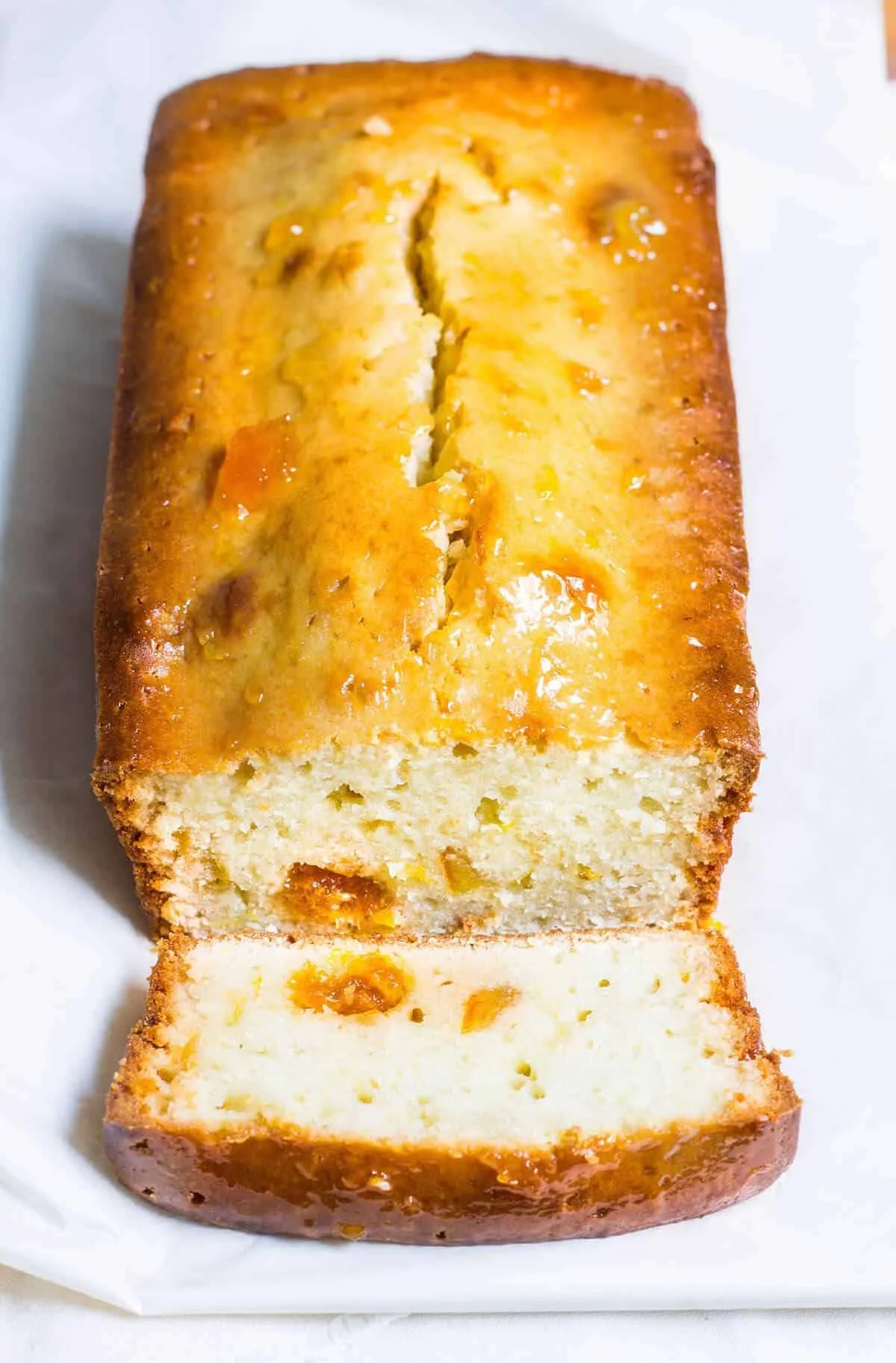 Sliced orange marmalade bread on a wooden board with a jar of marmalade