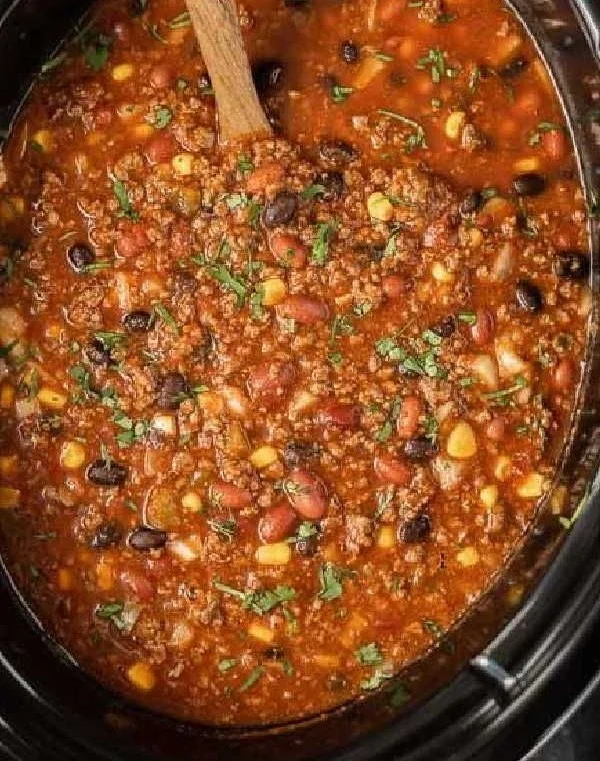 Bowl of slow cooker taco chili with toppings, showcasing a hearty meal.