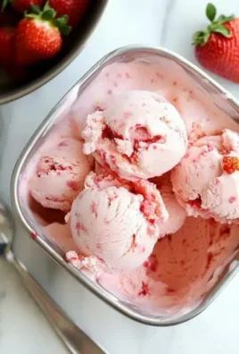 Strawberry cottage cheese ice cream in a bowl, garnished with fresh strawberries.