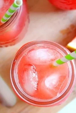 Refreshing watermelon lemonade served in a glass with lemon slices and mint.